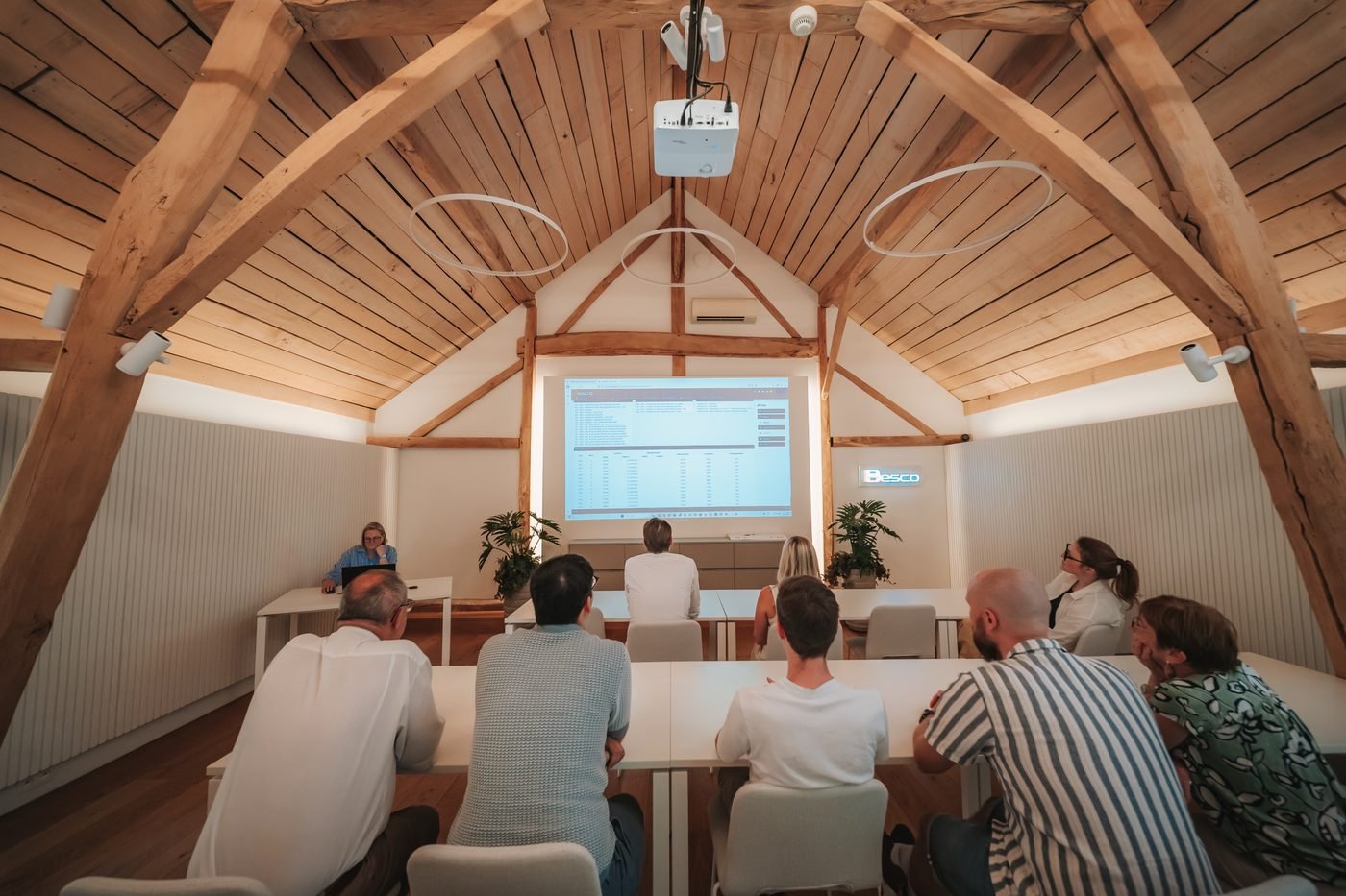 Deelnemers volgen een opleiding in de vergaderzaal van Besco onder het houten dak